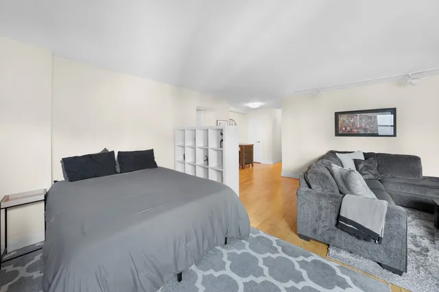 a living room with furniture a rug and white walls