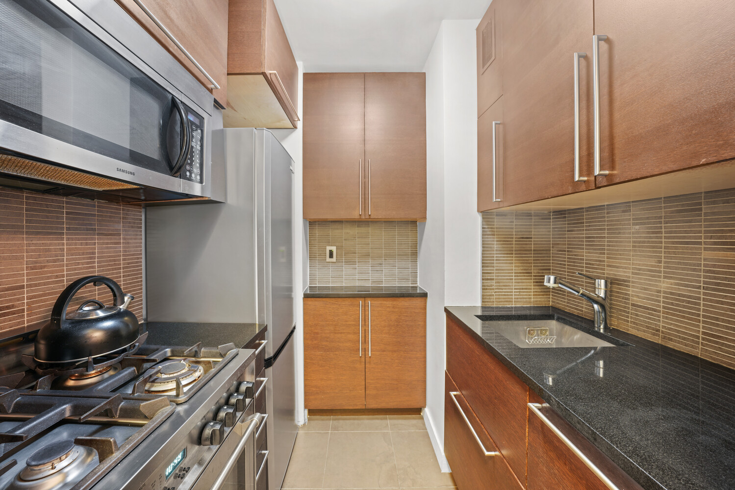 101 West 12th Street, Unit 9Z Manhattan, NY 10011 - Photo 7 of 15 a kitchen with a sink stove and cabinets