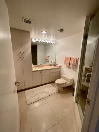 a large white room with a mirror and a toilet