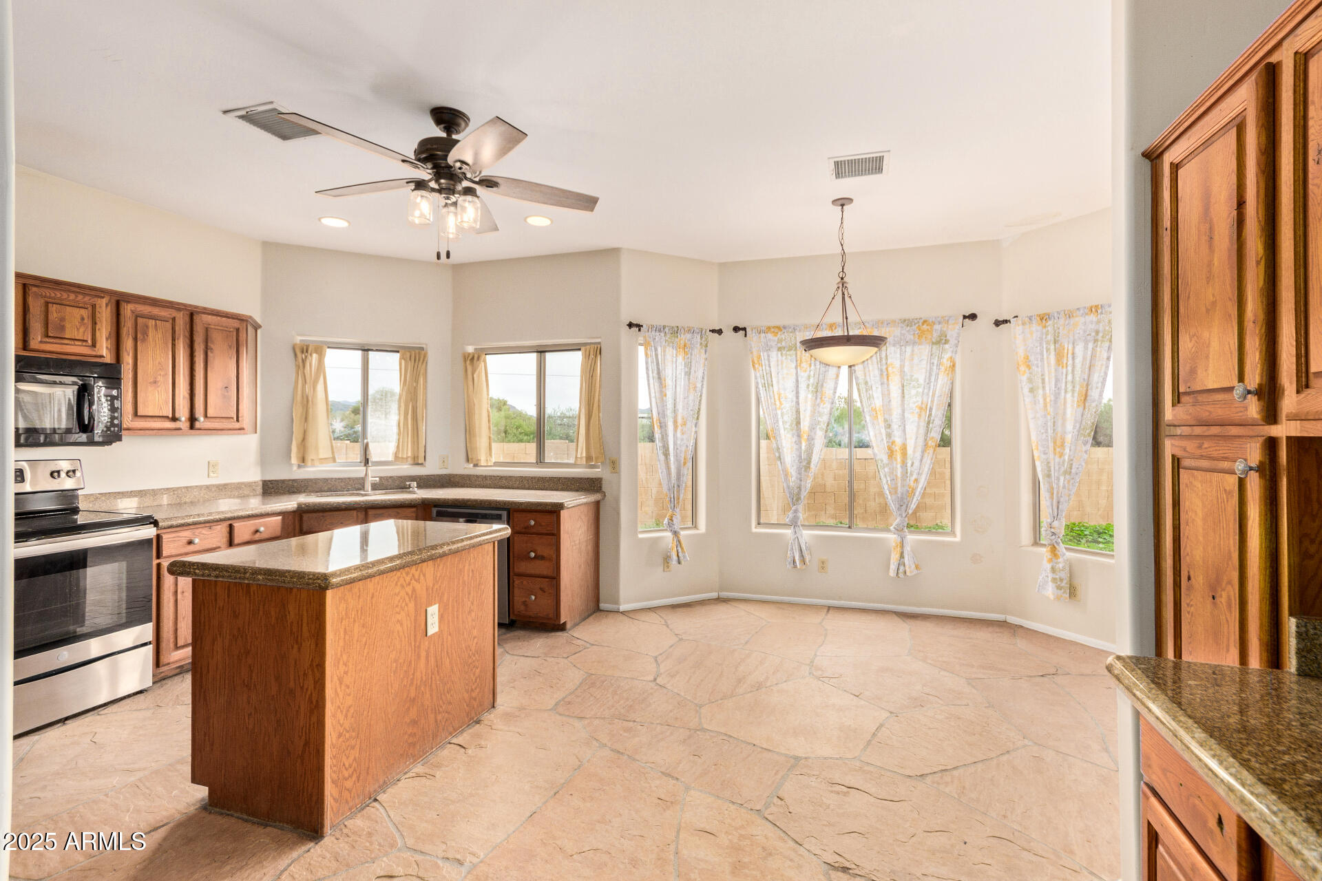 1032 East Carlise Road Phoenix, AZ 85086 - Photo 15 of 56 a large kitchen with stainless steel appliances granite countertop a stove top oven a sink a counter space and cabinets