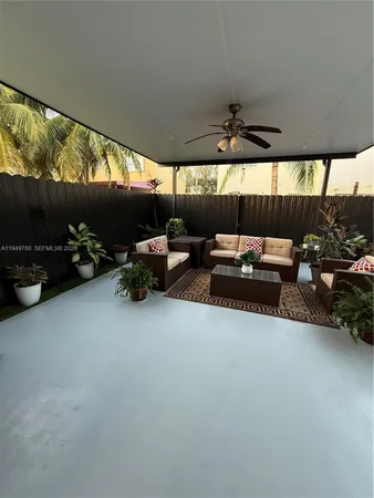 a living room with furniture a flat screen tv and a floor to ceiling window