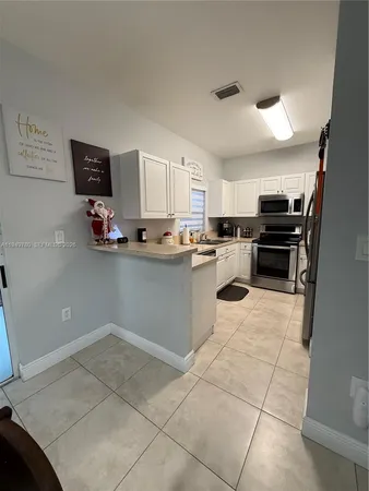 a kitchen with kitchen island a counter top space appliances and a window