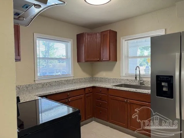 a kitchen with stainless steel appliances granite countertop a sink stove and cabinets