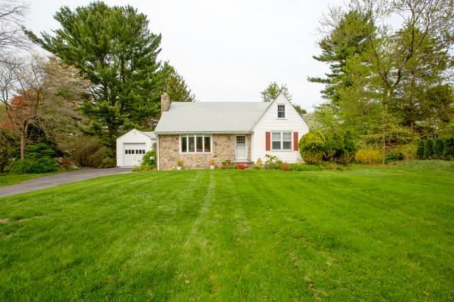 a front view of a house with a yard and trees