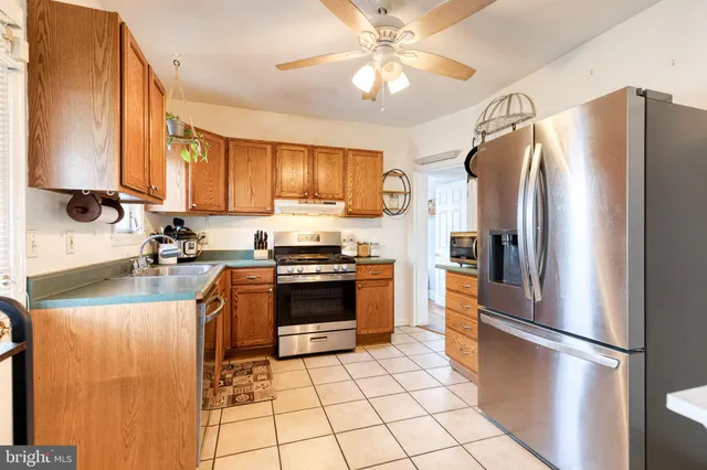a kitchen with stainless steel appliances granite countertop a refrigerator a stove a sink and dishwasher