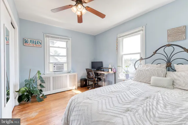 a bedroom with a bed and a large window