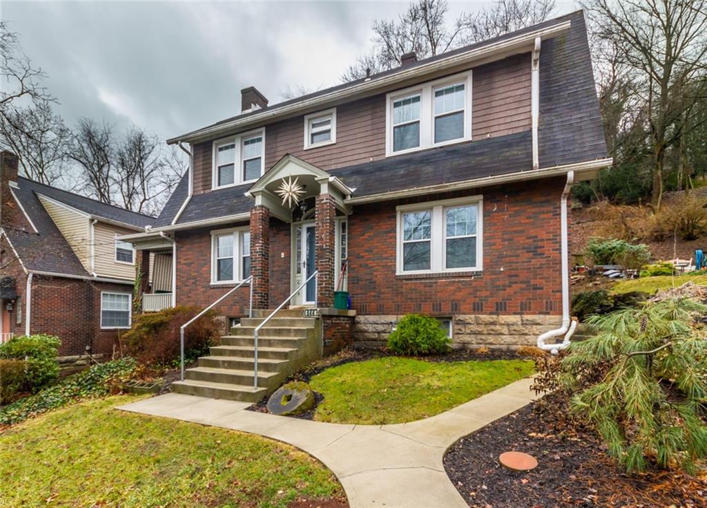 a front view of a house with a garden and plants