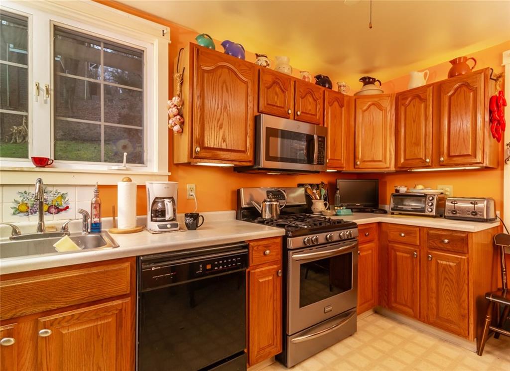 644 Cascade Road Pittsburgh, PA 15221 - Photo 9 of 21 a kitchen with stainless steel appliances granite countertop a stove top oven a sink dishwasher and cabinets with wooden floor