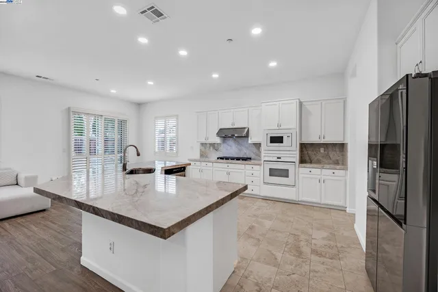 a large kitchen with stainless steel appliances lots of counter space and wooden floor