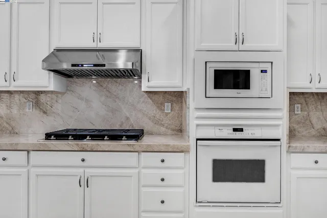 a kitchen with granite countertop a sink and a stove