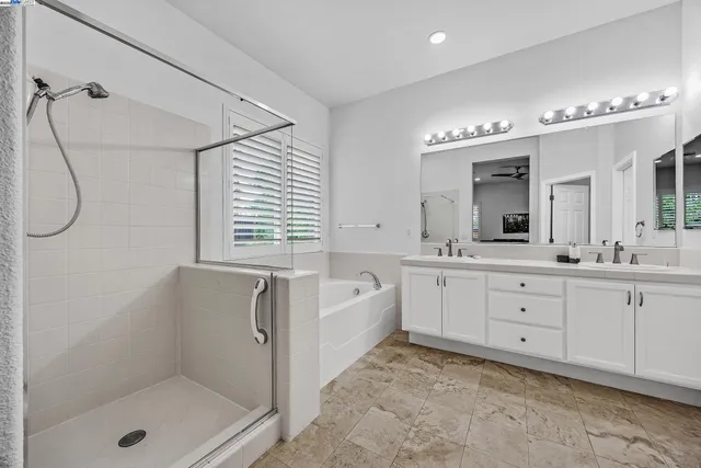 a spacious bathroom with double sink a toilet and a bathtub