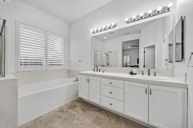 a bathroom with a double vanity sink mirror double and bathtub