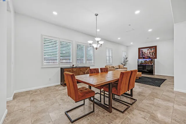 a living room with furniture a dining table and a chandelier