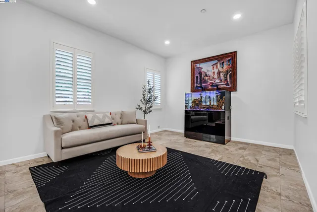 a living room with furniture a fireplace and a potted plant