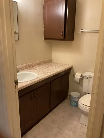 a bathroom with a granite countertop toilet sink and mirror