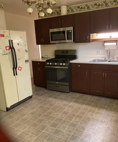 a kitchen with stainless steel appliances a stove a microwave and a refrigerator