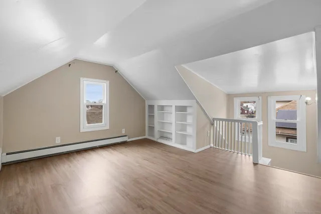 a view of an empty room with wooden floor and closet