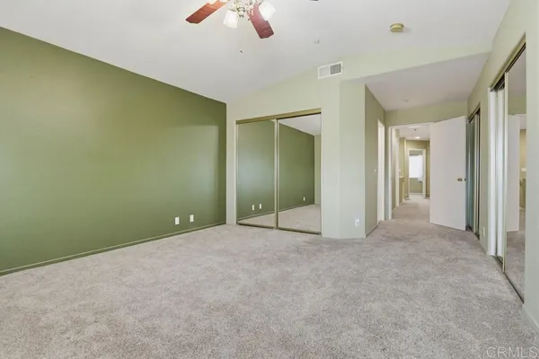 an empty room with closet and fan