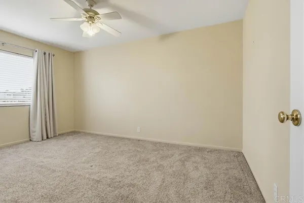an empty room with windows and fan
