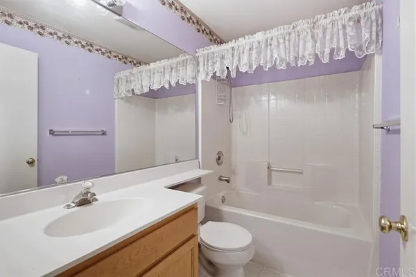 a bathroom with a sink a toilet a mirror and shower