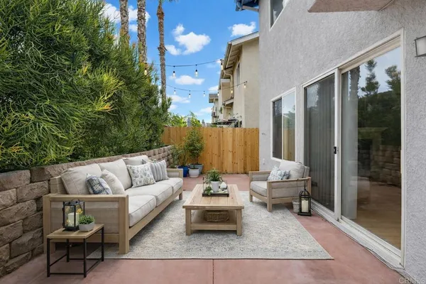 a view of a patio with couches and a potted plant on a table