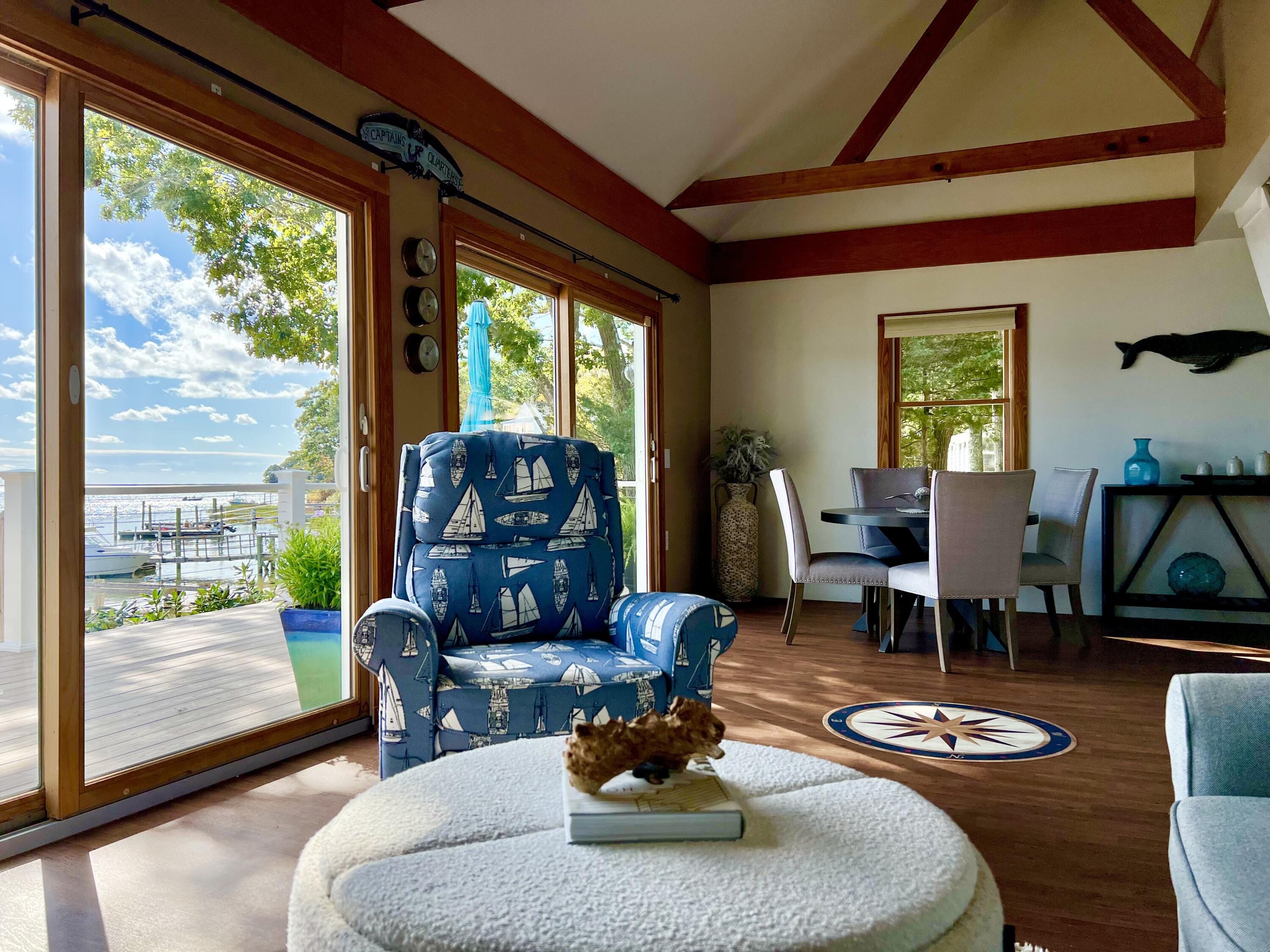 72 Captains Row Mashpee, MA 02649 - Photo 15 of 40 a dining room with furniture a rug a fireplace and a floor to ceiling window