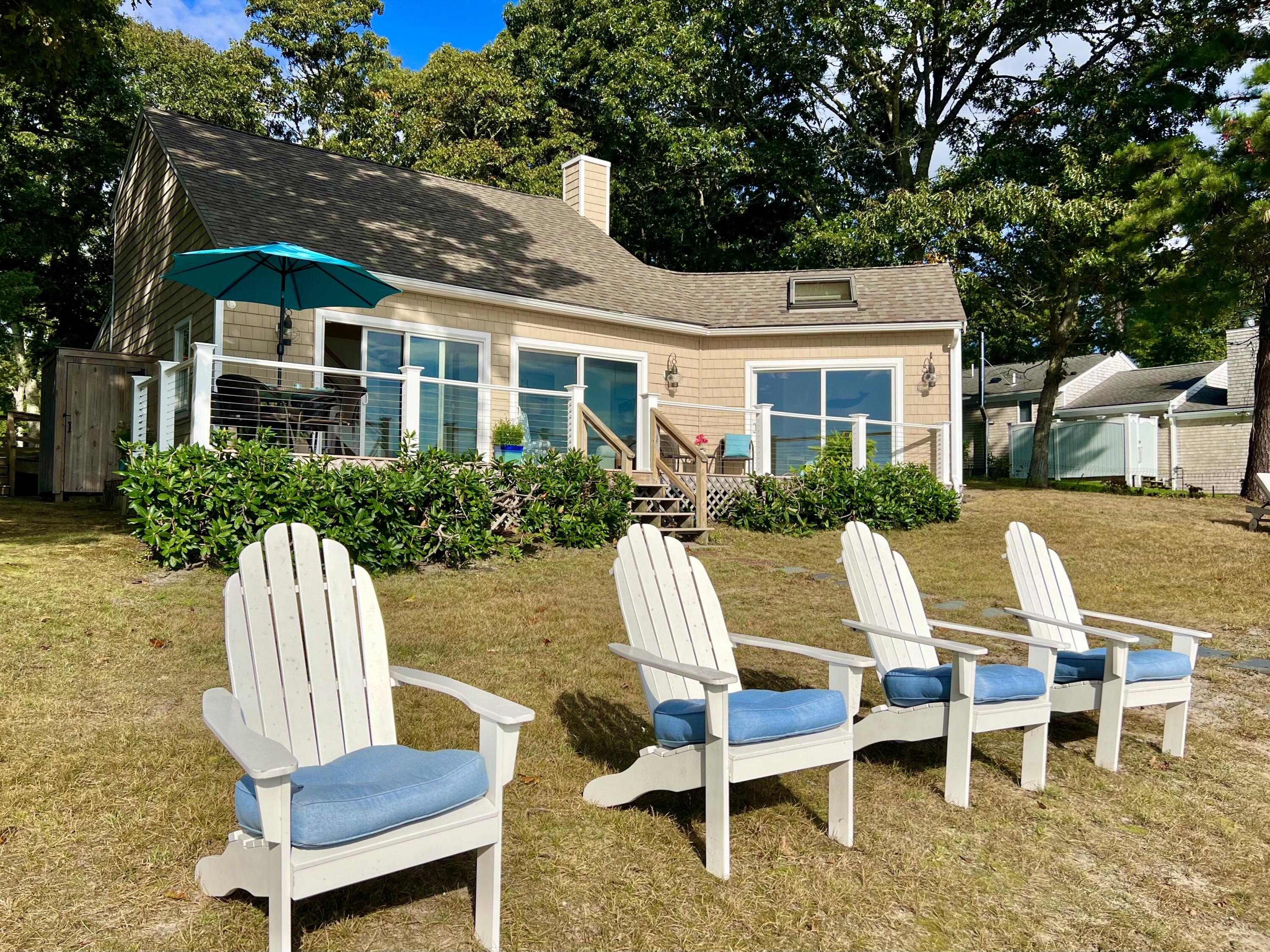 72 Captains Row Mashpee, MA 02649 - Photo 32 of 40 a view of a patio with table and chairs with wooden fence