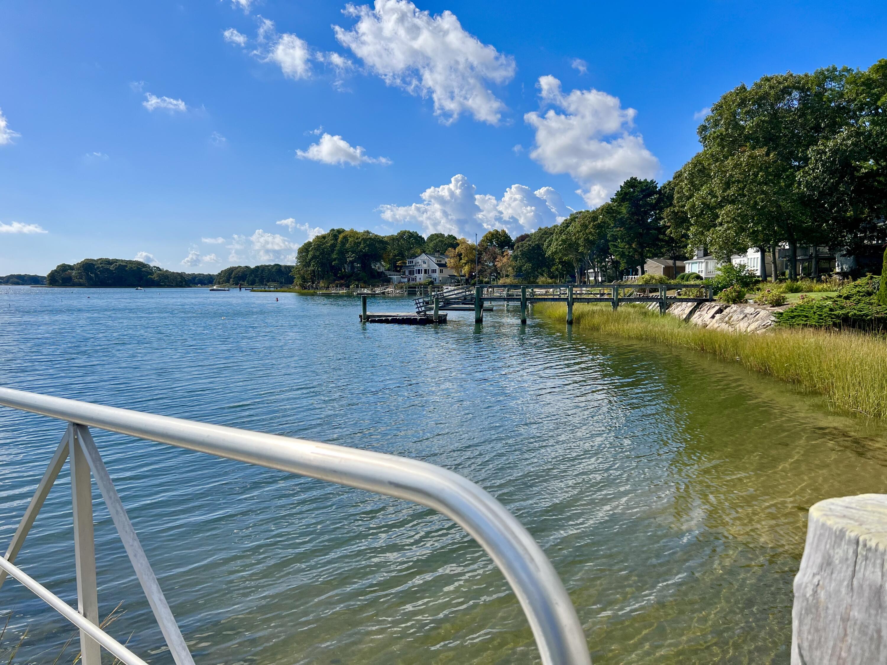 72 Captains Row Mashpee, MA 02649 - Photo 39 of 40 a view of a swimming pool with lake and houses in the back