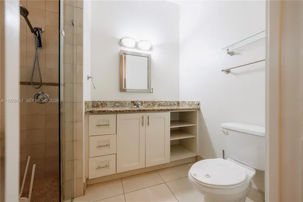 a bathroom with a granite countertop toilet sink and a mirror