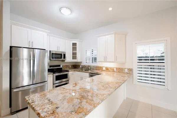 a kitchen with stainless steel appliances granite countertop a refrigerator sink stove and microwave