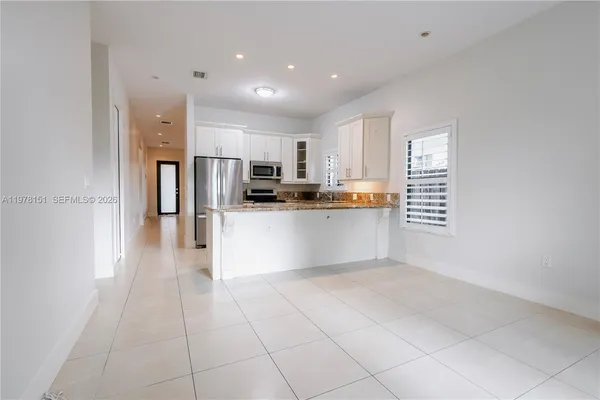 a kitchen with stainless steel appliances a refrigerator sink and microwave