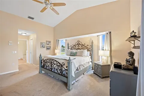 a bedroom with a bed a television and a large window