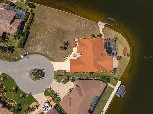 an aerial view of a house with swimming pool and lake view