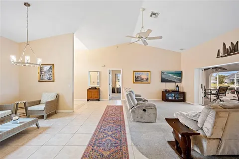a living room with furniture a flat screen tv and a chandelier