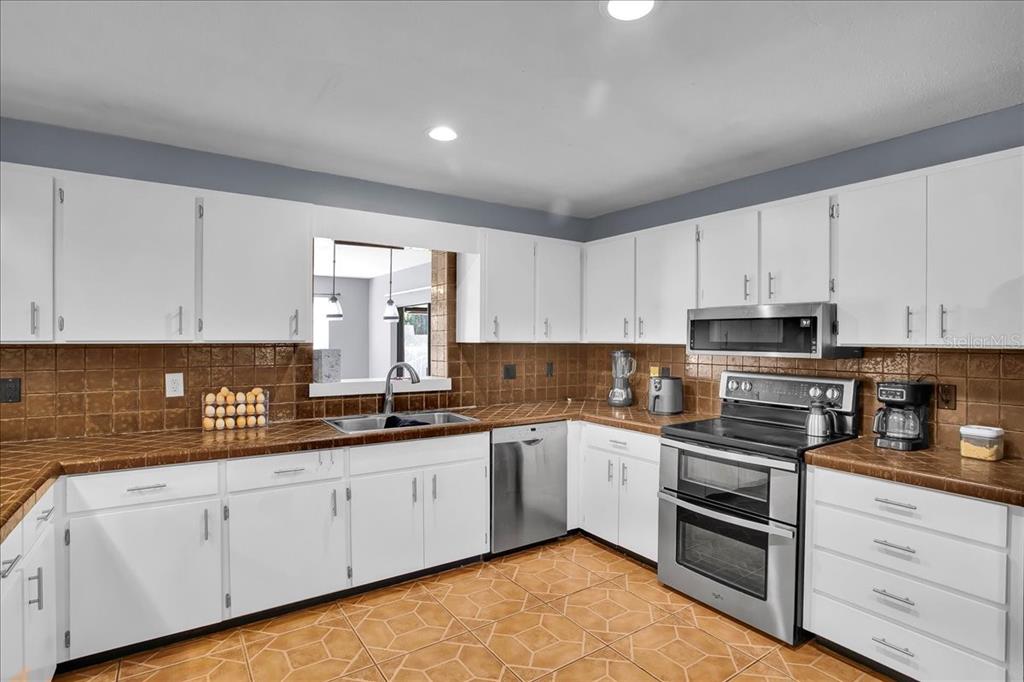 6124 Lynn Road Tampa, FL 33625 - Photo 45 of 84 a kitchen with granite countertop white cabinets stainless steel appliances and a sink