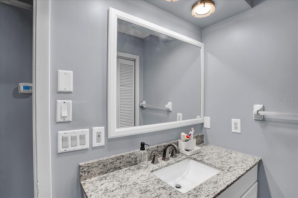 6124 Lynn Road Tampa, FL 33625 - Photo 71 of 84 a bathroom with a granite countertop sink and a mirror