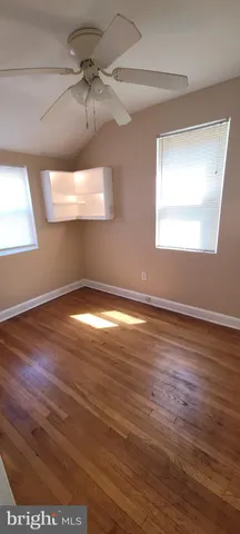 a view of a big room with wooden floor and windows
