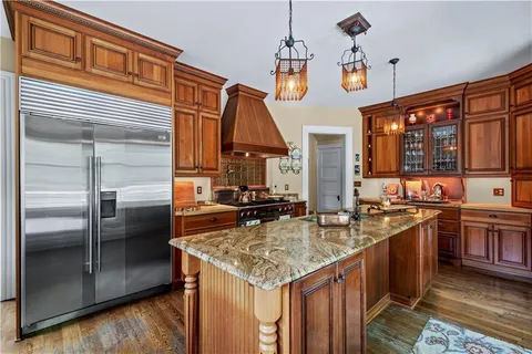 a kitchen with stainless steel appliances granite countertop a sink and a refrigerator