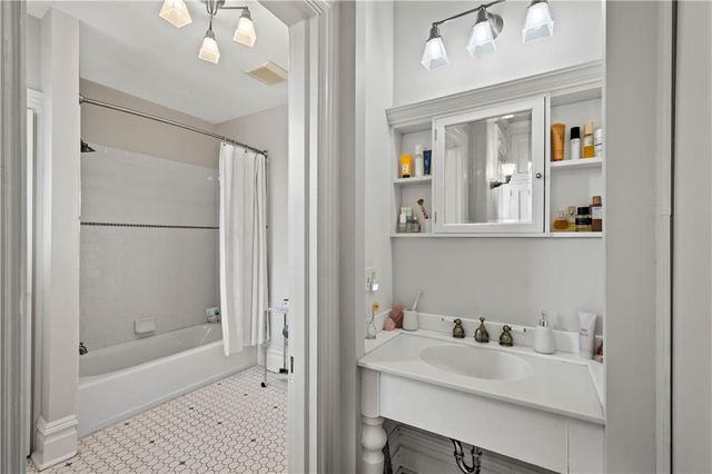 a bathroom with a sink vanity tub and shower