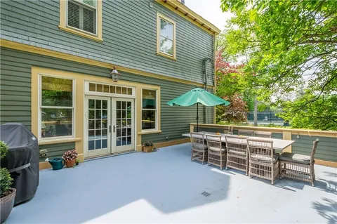 a view of a house with a barbeque and wooden fence