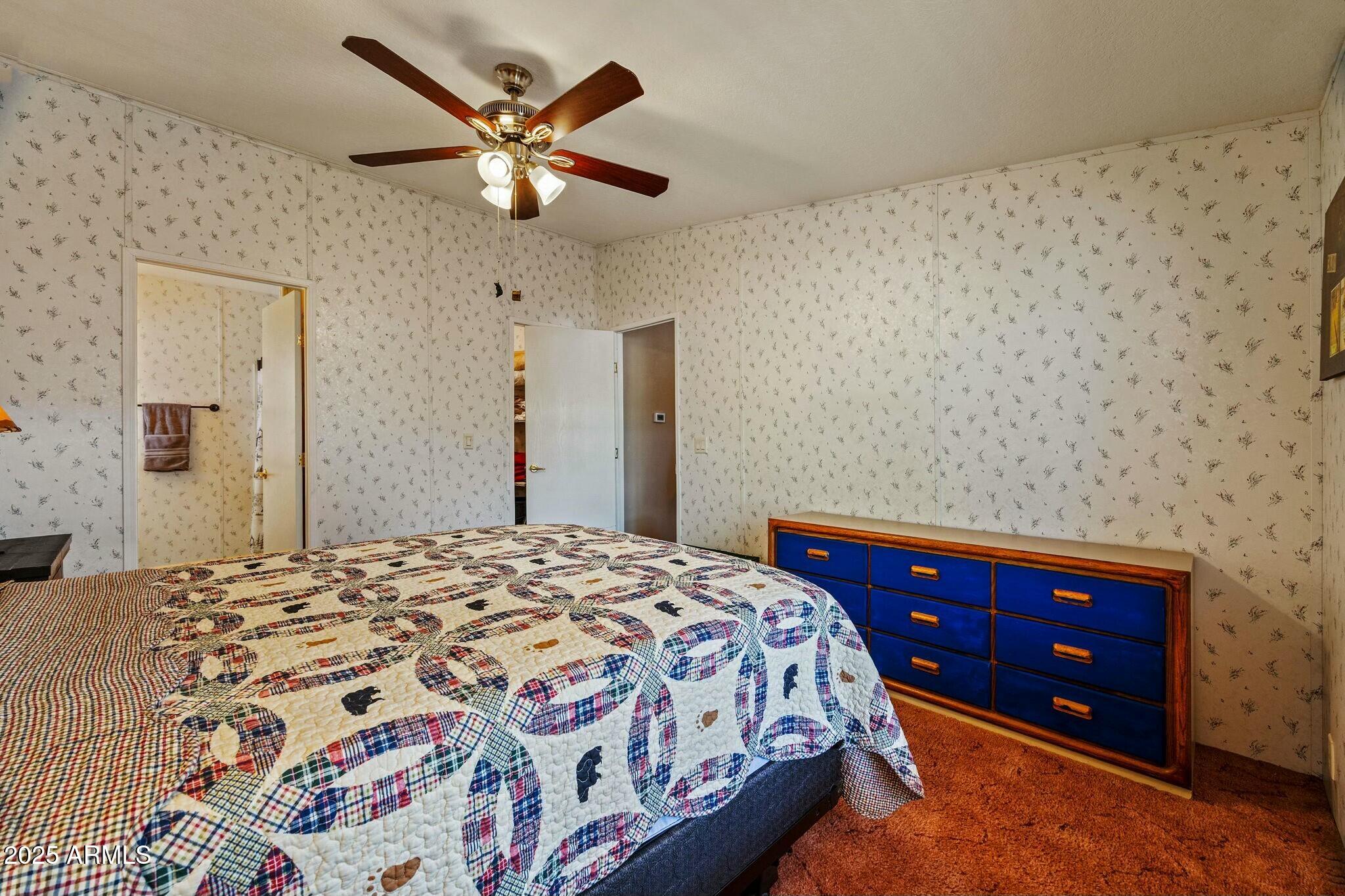 2893 Lazy Bear Trail Overgaard, AZ 85933 - Photo 15 of 34 a bedroom with a bed and a dresser with wooden floor