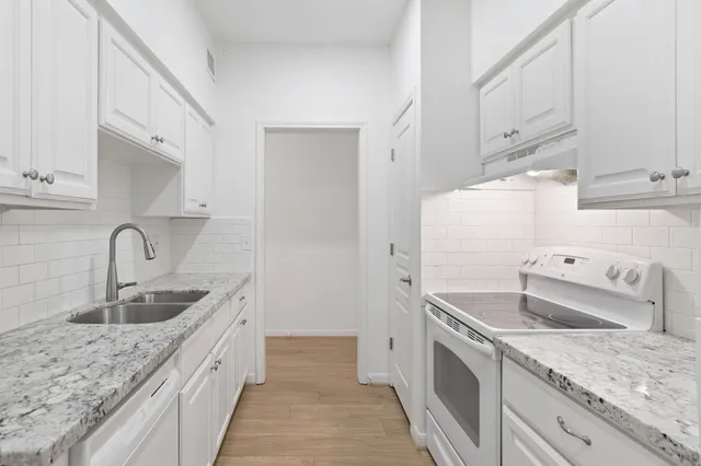 a kitchen with sink a refrigerator and cabinets
