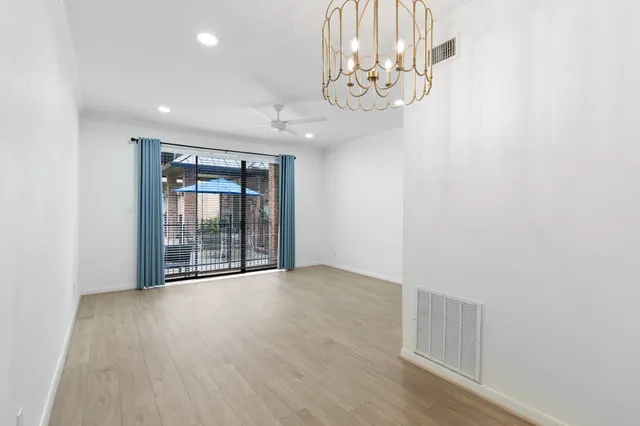 en empty room with wooden floor and fan