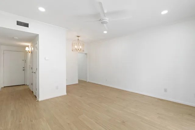 an empty room with wooden floor and mirror