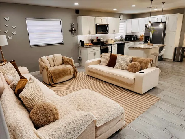 a living room with furniture kitchen and a view of kitchen