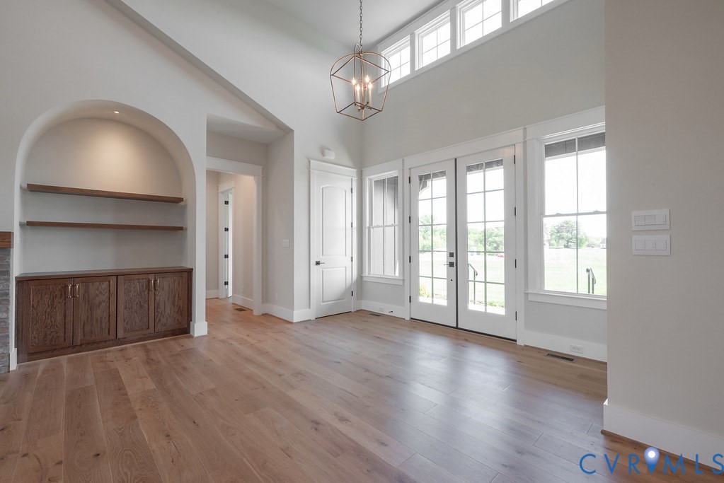 3530 Old Gun Road West Midlothian, VA 23113 - Photo 8 of 50 an empty room with wooden floor chandelier and windows
