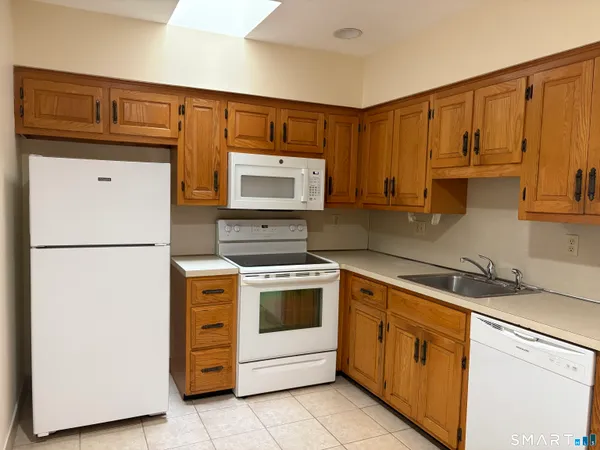 a kitchen with stainless steel appliances granite countertop a refrigerator stove a sink and dishwasher with wooden cabinets