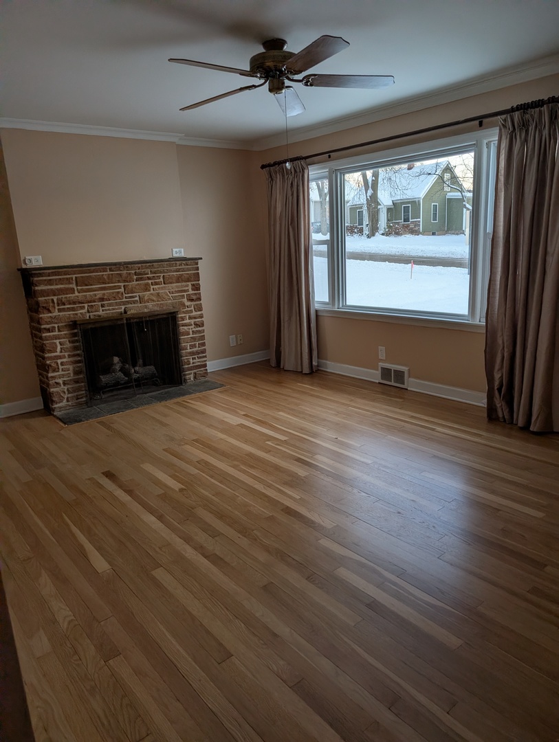3618 Maple Avenue McHenry, IL 60050 - Photo 3 of 15 an empty room with wooden floor fireplace and windows