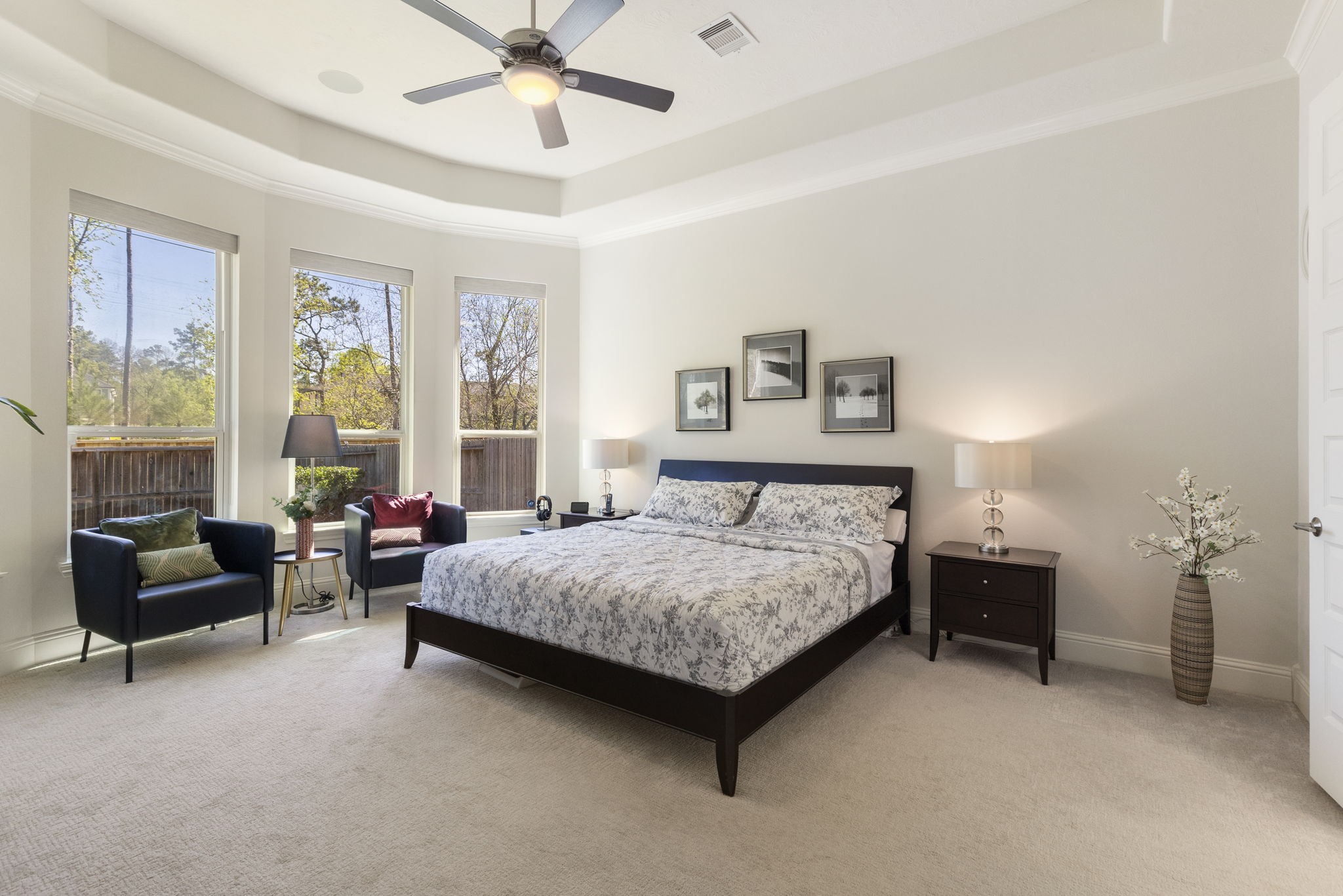 4115 Flagstone Pine Lane Spring, TX 77386 - Photo 14 of 40 The first-floor primary suite is a private retreat, thoughtfully located in its own wing for ultimate seclusion. Featuring a cozy sitting area, this serene space overlooks the tranquil backyard and a lush private treeline, creating a peaceful haven to relax and unwind at the end of the day.