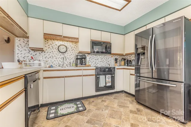 a kitchen with stainless steel appliances granite countertop a refrigerator sink and microwave